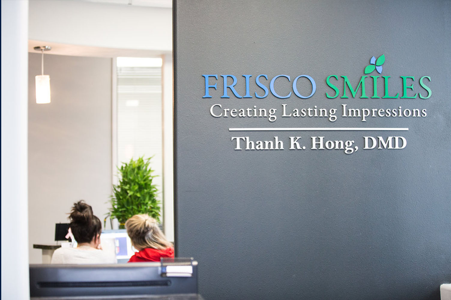 The image shows an interior space with a sign on a wall advertising Fresco Smiles, which appears to be a dental practice specializing in creating lasting impressions, and includes text that mentions Thank K. Hong, DMD.